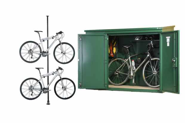 Photo of a bike stand with two bikes in it and a green metal bike shed on a white background